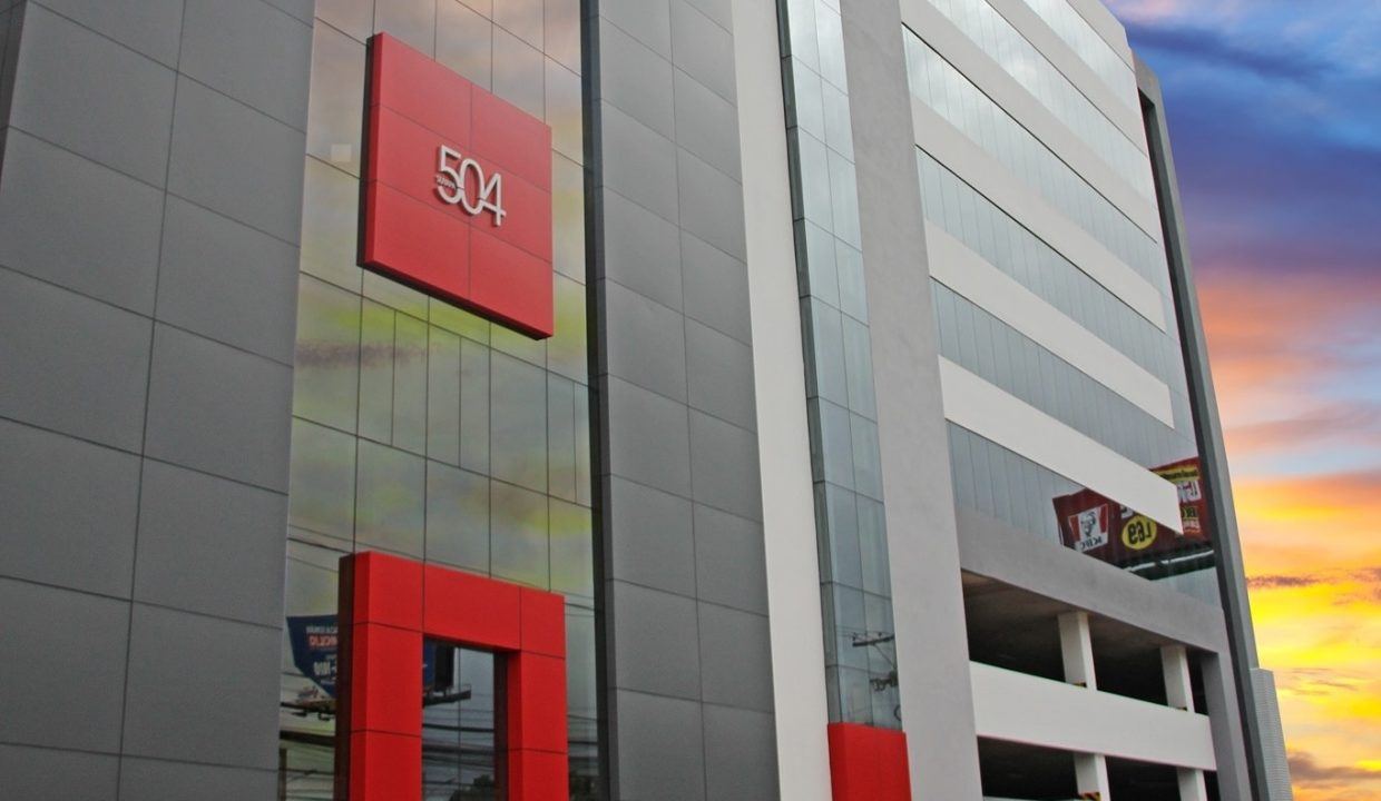 Señalética roja '504' en la fachada de la torre, vista en ángulo contra el cielo